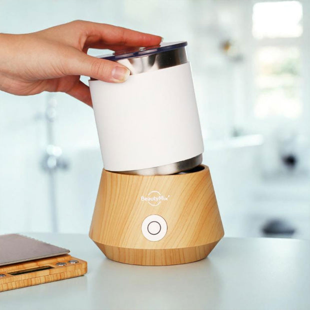 Flacon de sérum anti-âge Stellar BeautyMix sur fond rose avec taches blanches, idéal pour soin visage professionnel.